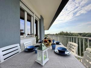 a table with blue dishes on top of a balcony at Residence Oceanico in Lignano Sabbiadoro