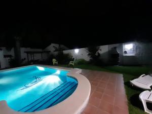 uma piscina num quintal à noite em Villa Lolera em Chiclana de la Frontera