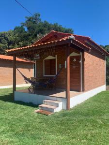 - un petit bâtiment avec une terrasse couverte dotée d'un hamac dans l'établissement Chalé Topázio no Recanto Diamantina entre Palmeiras e Capão, à Palmeiras