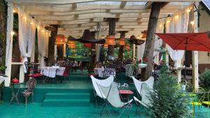 a dining room with tables and chairs at Casuta Din Padure Malaia in Malaia