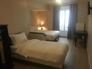 ein Hotelzimmer mit 2 Betten und einem Fenster in der Unterkunft le paris saint ouen in Paris