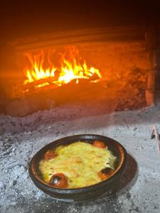 una sartén de comida frente a un horno de fuego en VILA DISHA, en Tirana