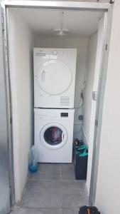 Waschmaschine und Trockner in einem kleinen Zimmer in der Unterkunft Charmante maison 3 Chambres avec Terrasse in Tourcoing