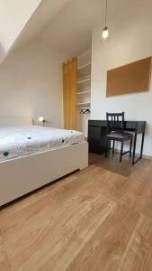 ein Schlafzimmer mit einem Bett, einem Stuhl und einem Tisch in der Unterkunft Charmante maison 3 Chambres avec Terrasse in Tourcoing