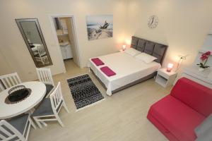 a bedroom with a bed and a table and a chair at Apartments Milanović in Herceg-Novi