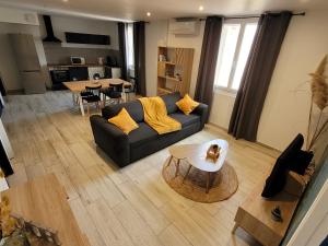 een woonkamer met een bank en een tafel bij centre de Thuir appart cosy in Thuir