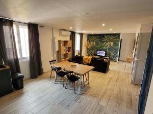 een woonkamer met een tafel en stoelen en een bank bij centre de Thuir appart cosy in Thuir