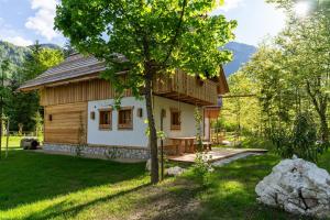 a small wooden house with a tree in front of it at ALPIK Chalets - Bohinj in Bohinj
