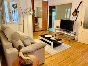 a living room with a couch and a flat screen tv at Con Encanto in San Sebastián +9 photos
