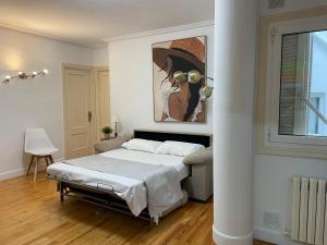 a bedroom with a bed and a painting on the wall at Con Encanto in San Sebastián