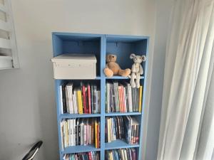 a book shelf with two teddy bears sitting on it at Loft mairie de Montreuil Paris in Montreuil