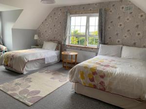 a bedroom with two beds and a window at Bayview Country House B&B in Ardara