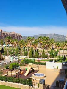 a playground with a slide in a park with palm trees at Holiday Marina D'or in Oropesa del Mar