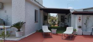 a patio with two chairs and a yard at La Maisonette in SantʼAndrea