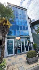 um edifício com janelas de vidro e uma palmeira em Oro Inn Hotel em Shkodër