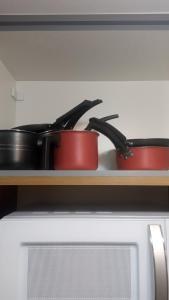 two pots and pans sitting on top of a microwave at The Flat 311 in Campinas