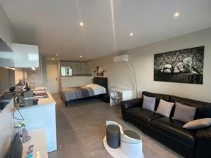 uma sala de estar com um sofá e um quarto em HELIOPOLIS CAP D'AGDE VILLAGE NATURISTE em Cap d'Agde