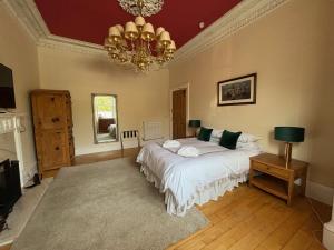 a bedroom with a bed and a chandelier at Clarin Guest House in Edinburgh