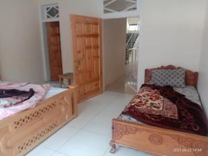 a bedroom with two beds and a door at New White Palace Hotel in Naran