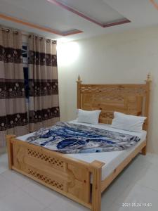 a bedroom with a wooden bed with a wooden frame at New White Palace Hotel in Naran