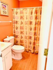 a bathroom with a toilet and a shower curtain at Cozy Little River Condo in Little River