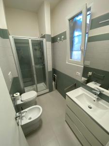 un bagno con lavandino, WC e specchio di Casetta di Renata a Lido di Ostia