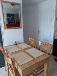 una mesa de madera con 4 sillas y un espejo en Chez Swan et Yuliya, en Mooslargue