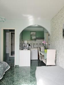 a kitchen with green cabinets and a table with chairs at Apartmani Mediteran in Vrh