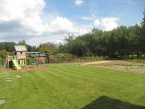 a large yard with a playground with a slide at Le Paradis d'Henri in Hannut