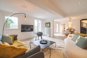 uma sala de estar com um sofá e uma mesa em Charmante maison proche centre-ville Reims em Reims