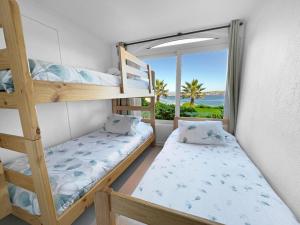 een slaapkamer met een stapelbed en uitzicht op de oceaan bij Puerto Velero Primera Línea Primer Piso al lado de la Playa! 8pax in Puerto Velero