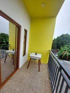 einen Balkon mit einem Tisch und einer gelben Wand in der Unterkunft Alleyhub Condotel 