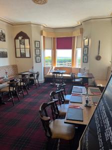 a restaurant with tables and chairs in a room at St Olaf Golf Hotel in Cruden Bay