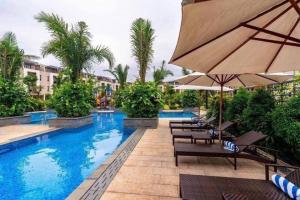 a pool at a hotel with chairs and an umbrella at Rosemary's in Ha Long