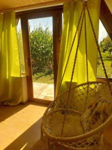 a swing in a room with a window at Village Serenity Cottage with outside toilet in Podgorica