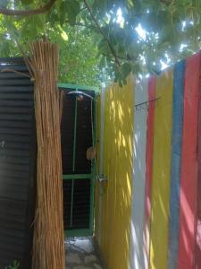 a colorful house with a tree next to a door at Village Serenity Cottage with outside toilet in Podgorica