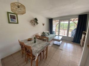a living room with a table and a couch at Appartement Biscarrosse lac-golf in Biscarrosse