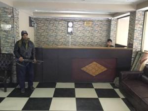 a man standing in a room with a bar at New Hilton Hotel in Naran