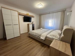 a bedroom with a bed and a television in it at Cluj Home due in Cluj-Napoca