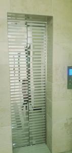 a shower stall with a glass door in a bathroom at New Hilton Hotel in Naran