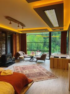 a bedroom with a bed and a large window at Lotus Çamlıhemşin Suit & Bungalov in Çamlıhemşin