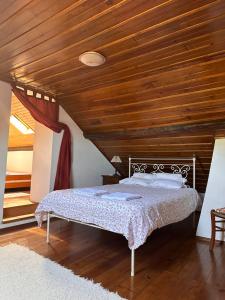 a bedroom with a bed with a wooden ceiling at Casa do largo in Casais do Chão da Mendiga
