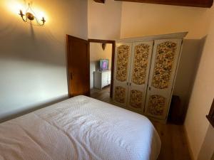 ein Schlafzimmer mit einem weißen Bett und einem Schrank in der Unterkunft I Pascoli in Roana