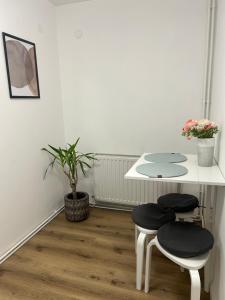 ein weißer Tisch mit 2 Stühlen und ein Tisch mit Blumen in der Unterkunft Cluj Home due in Cluj-Napoca