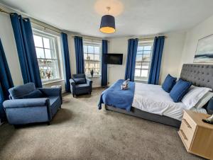 Graham Arms Inn في Longtown: غرفة نوم مع ستائر زرقاء وسرير وكرسي