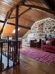 sala de estar con sofá y pared de piedra en Casa do largo en Casais do Chão da Mendiga