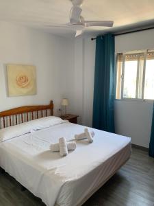 1 dormitorio con 1 cama con 2 toallas en SERVICE APART LAZARO- Apartamentos Aguamarina 49, en Calpe