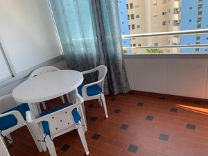 stół i 2 krzesła w pokoju z oknem w obiekcie SERVICE APART LAZARO- Apartamentos Aguamarina 49 w mieście Calpe