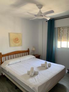 sypialnia z białym łóżkiem i wentylatorem sufitowym w obiekcie SERVICE APART LAZARO- Apartamentos Aguamarina 49 w mieście Calpe