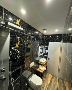 een badkamer met 2 wastafels, een toilet en een douche bij Hotel Europa Kruje in Krujë
